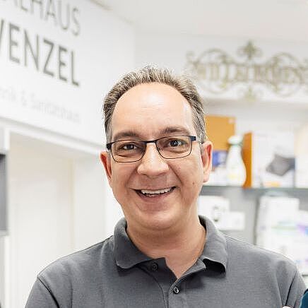 Optica Omnia Kunde Manfred Wenzel in seinem Ladengeschäft mit einer Prothese